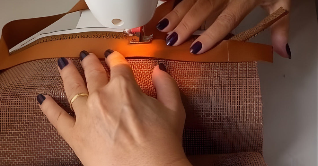 imagem aproximada de mãos femininas costurando uma bolsa em máquina de costura caseira